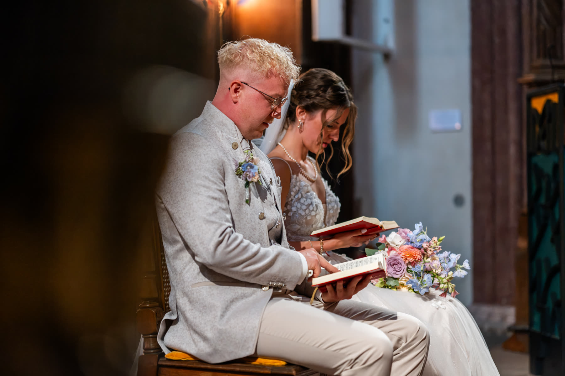 Brautpaar liest gemeinsam während der Trauung in der Kirche, Schwarz-Weiß